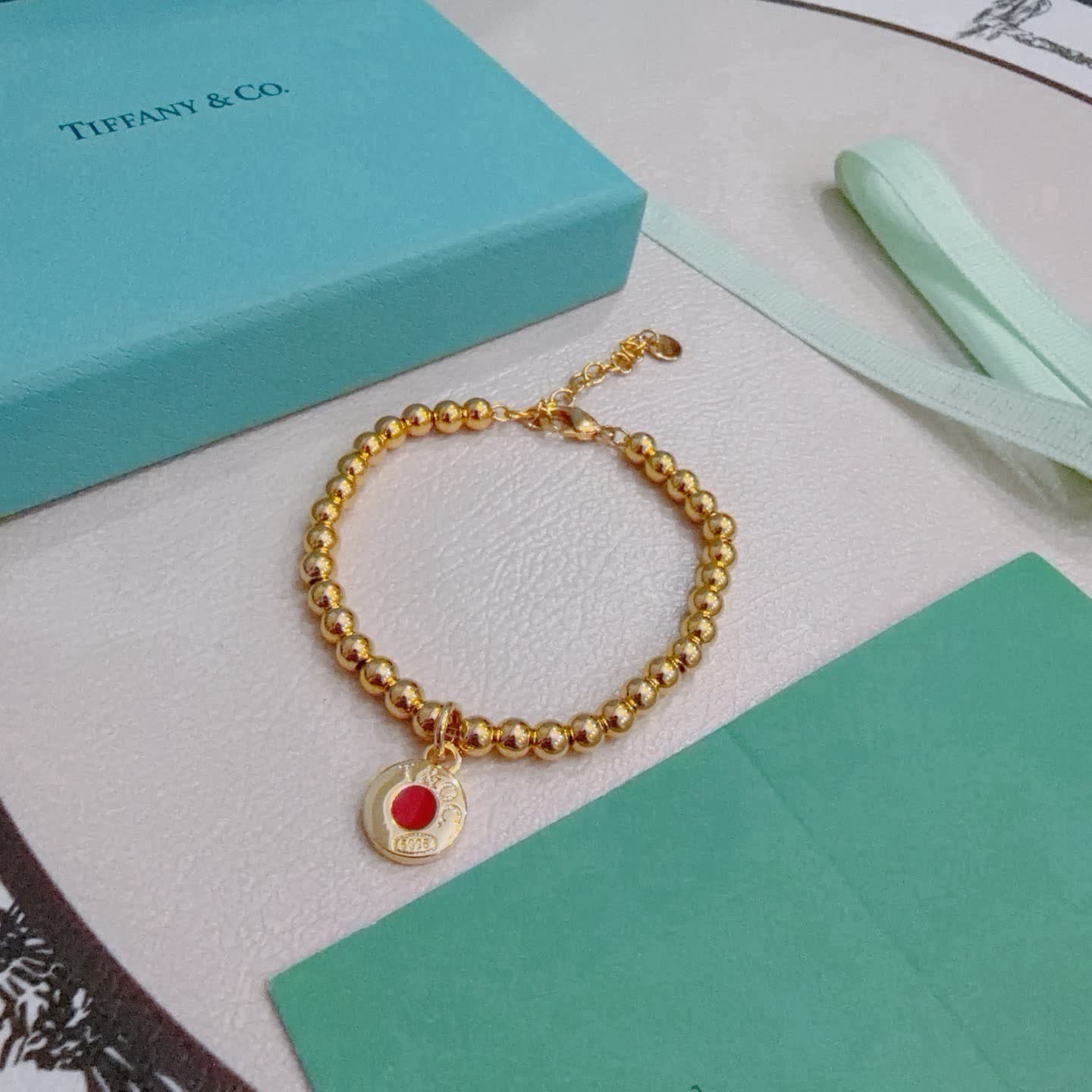 Tiffany & Co. Gold Bead Bracelet with Red Enamel Charm
